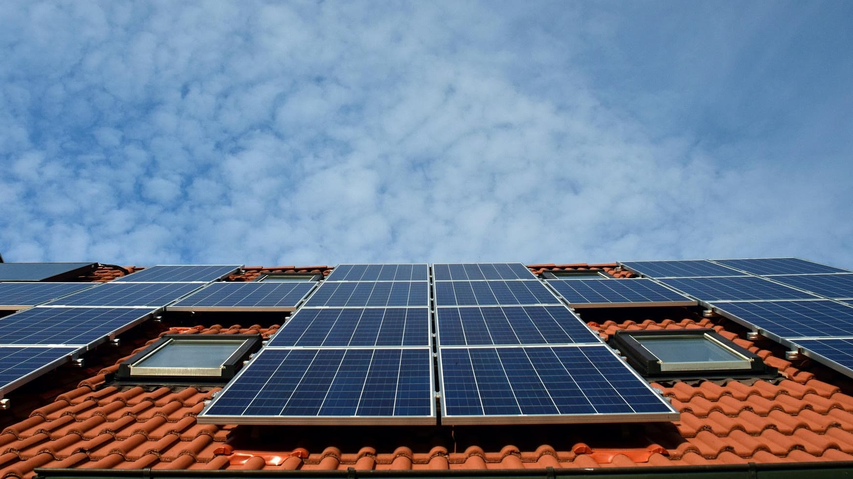 Ältere Photovoltaikanlage mit blauen Modulen auf einem Ziegeldach